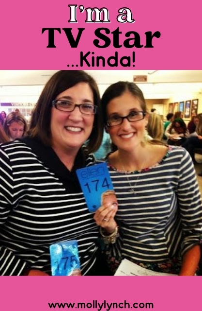 Two women wearing striped shirts smile and hold numbered cards while sitting indoors. The image has pink text above and below referencing being a TV star.