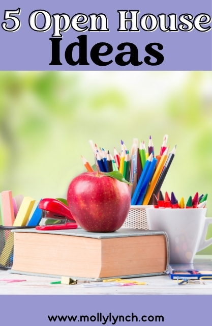 A red apple and a red stapler sit on a closed book, surrounded by colorful pencils, pens, and markers in containers.