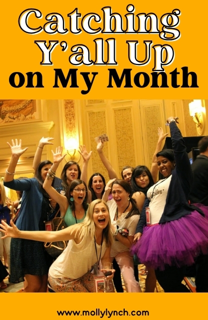 A group of people pose excitedly indoors at an event, some smiling and waving their arms, under text reading “Catching Y’all Up on My Month.”.