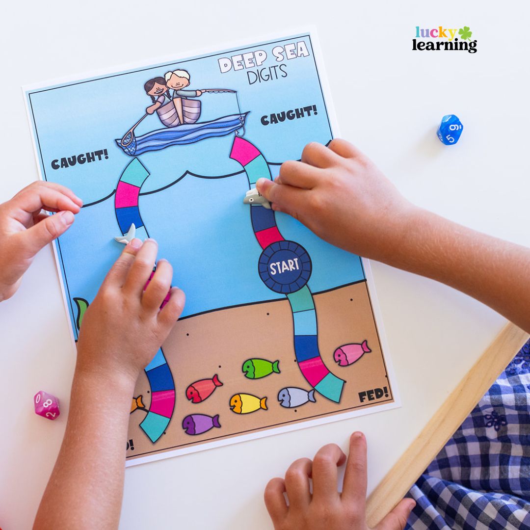 Two children play a math board game called "Deep Sea Digits," using fish-shaped pieces and colorful dice—a fun way to boost math fact fluency games at the table.