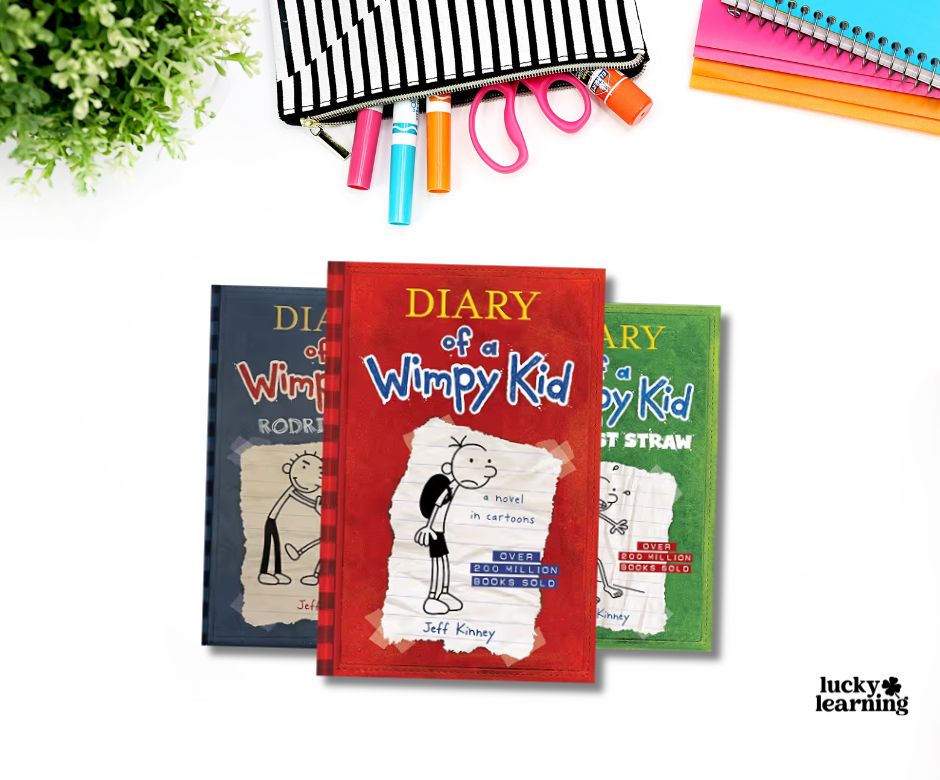 Three "Diary of a Wimpy Kid" books by Jeff Kinney, part of the bestselling book series, are arranged on a white surface with stationery and a green plant nearby.